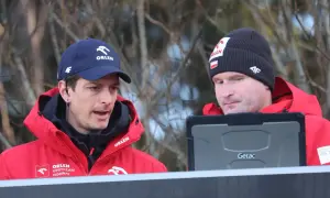 Dwóch trenerów w czerwonych kurtkach Orlen analizuje dane na tablecie. To oni decydują, kto trenuje polskich skoczków.