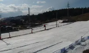 Widok z białka tatrzańska webcam na ośnieżony stok narciarski z wyciągiem krzesełkowym i wieżą w tle.