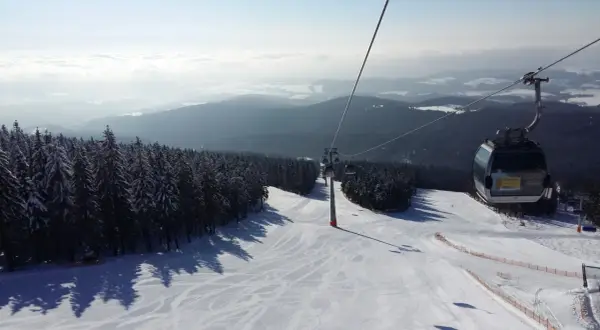 Widok z kolejki linowej na ośnieżony stok narciarski. Sprawdź jańskie łaźnie ski cennik i zaplanuj swój wyjazd!